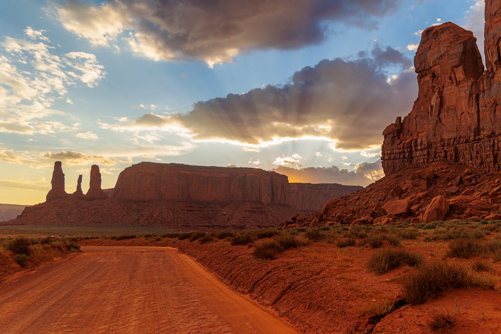 Stunning sunset view of Monument Valley's iconic rock formations with dramatic light and shadow play.
